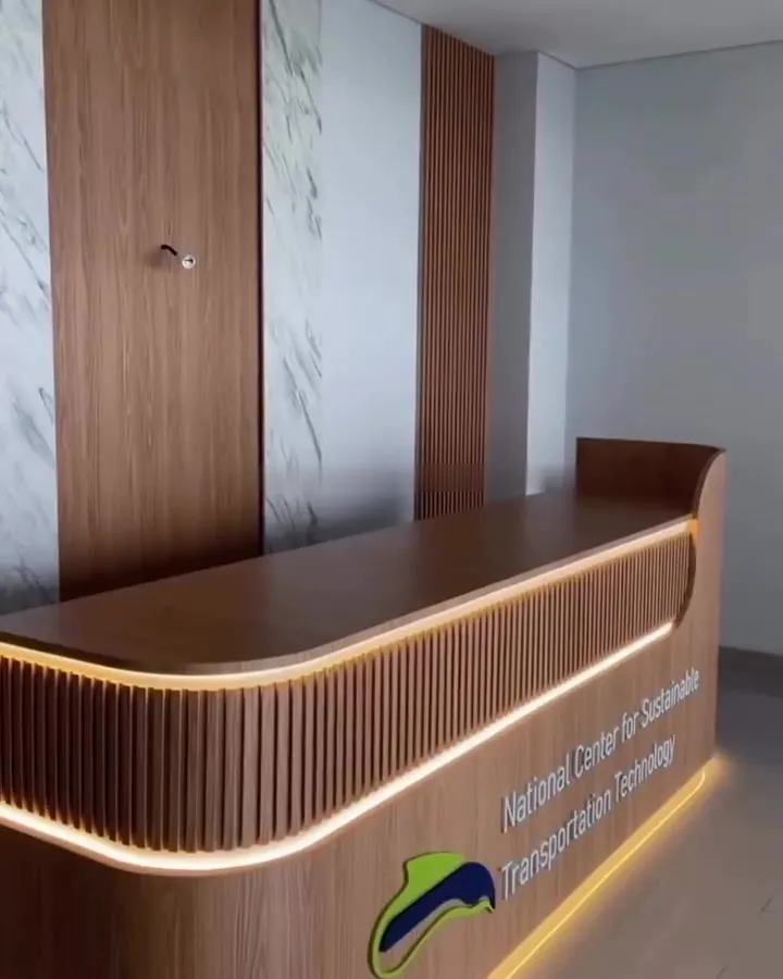 Interior Lobi NCSTT ITB — Lobi gedung riset dengan dinding bilah kayu yang melengkung mulus mengikuti bentuk ruang.
