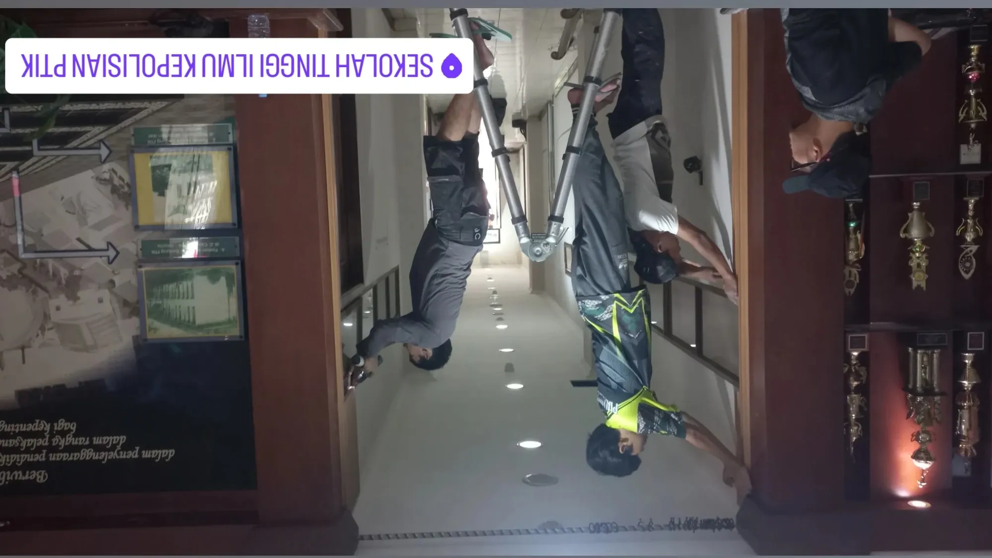 Koridor STIK — Koridor lembaga pendidikan dengan dinding berwarna cokelat hangat dan panel display.